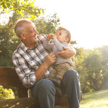 old man and a baby sitting on his lap playing